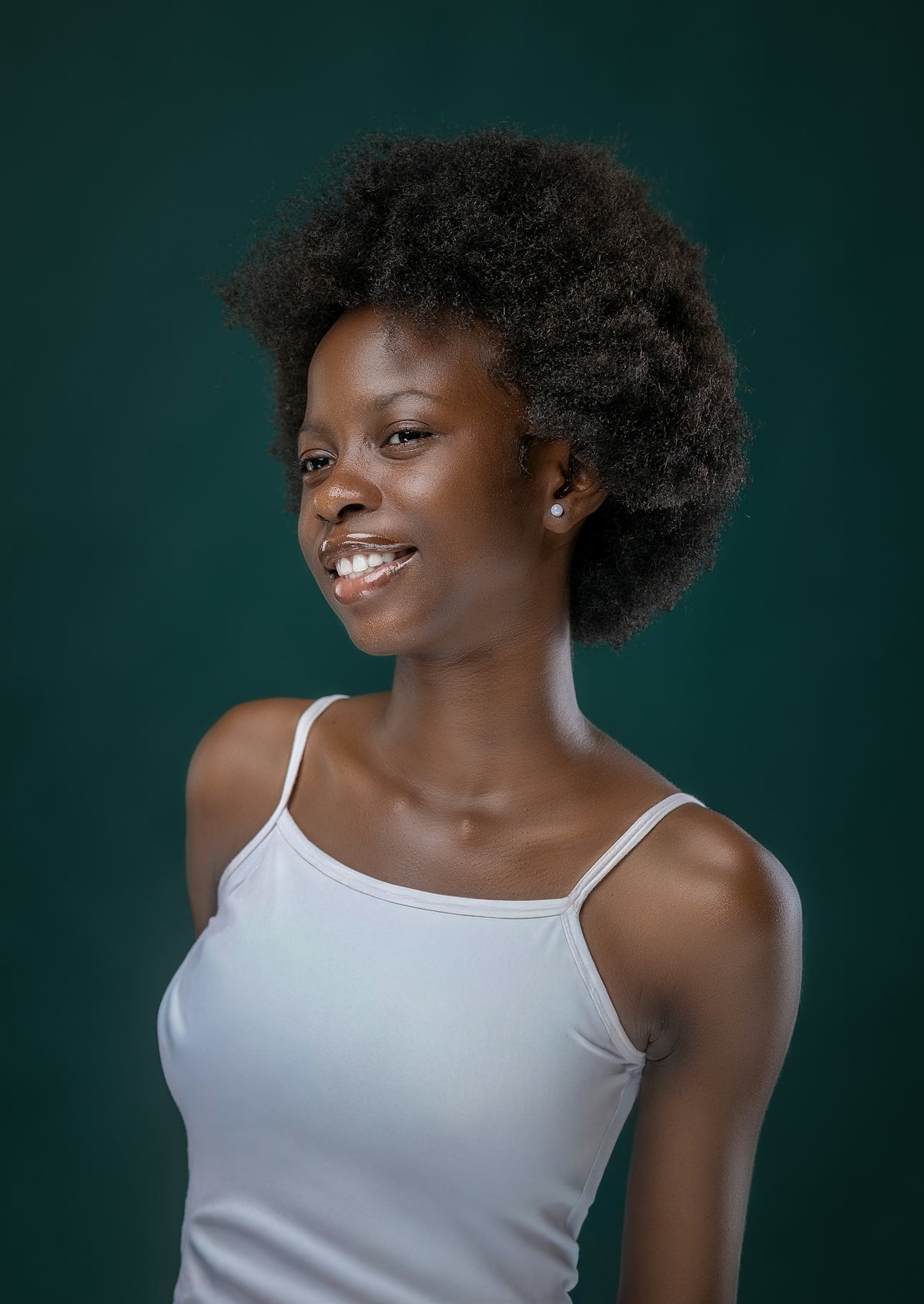 A young black woman with an afro smiles.