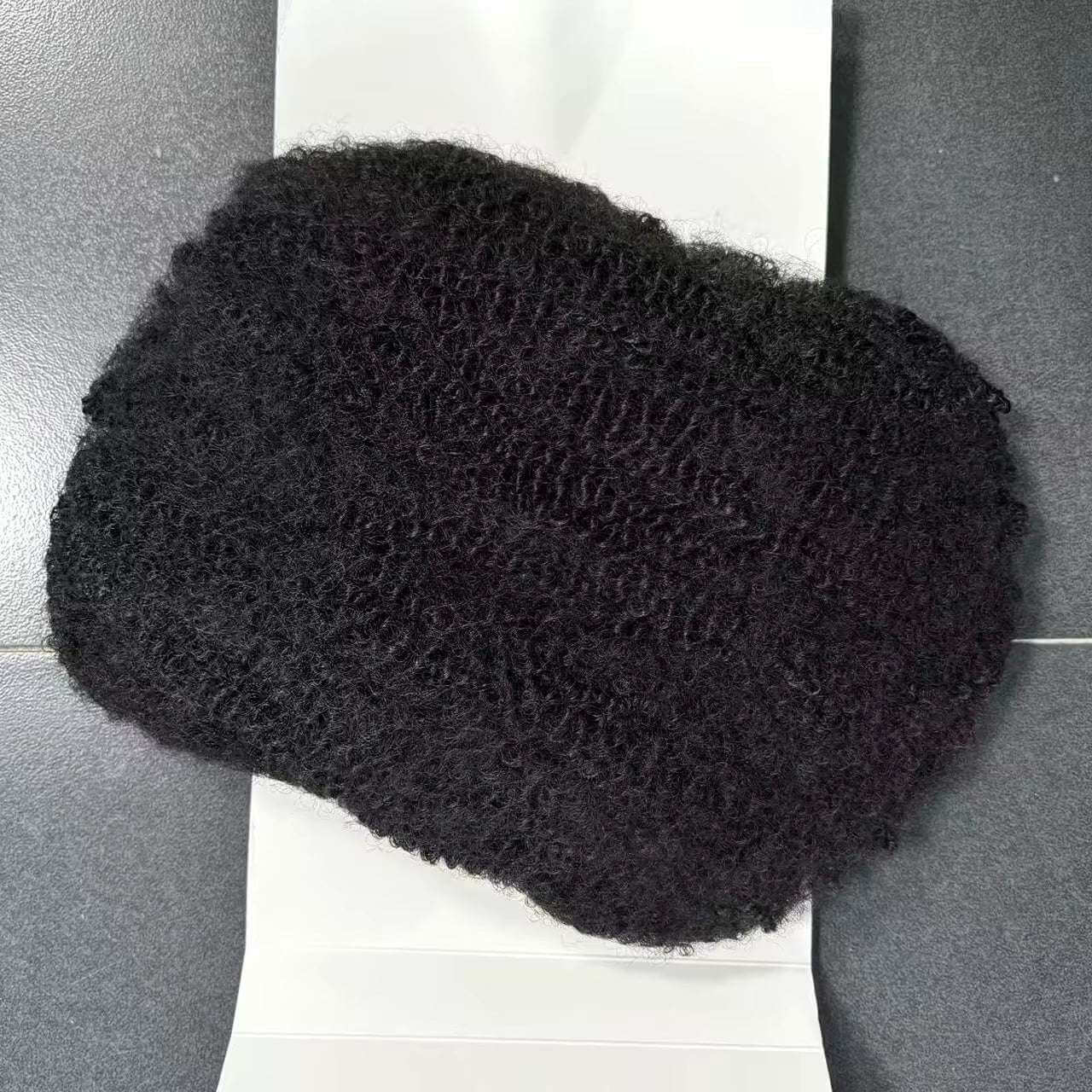 100g 12" Soft Texture Afro Kinky Bulk Hair Extension displayed on a flat surface, showcasing its soft, bouncy texture.