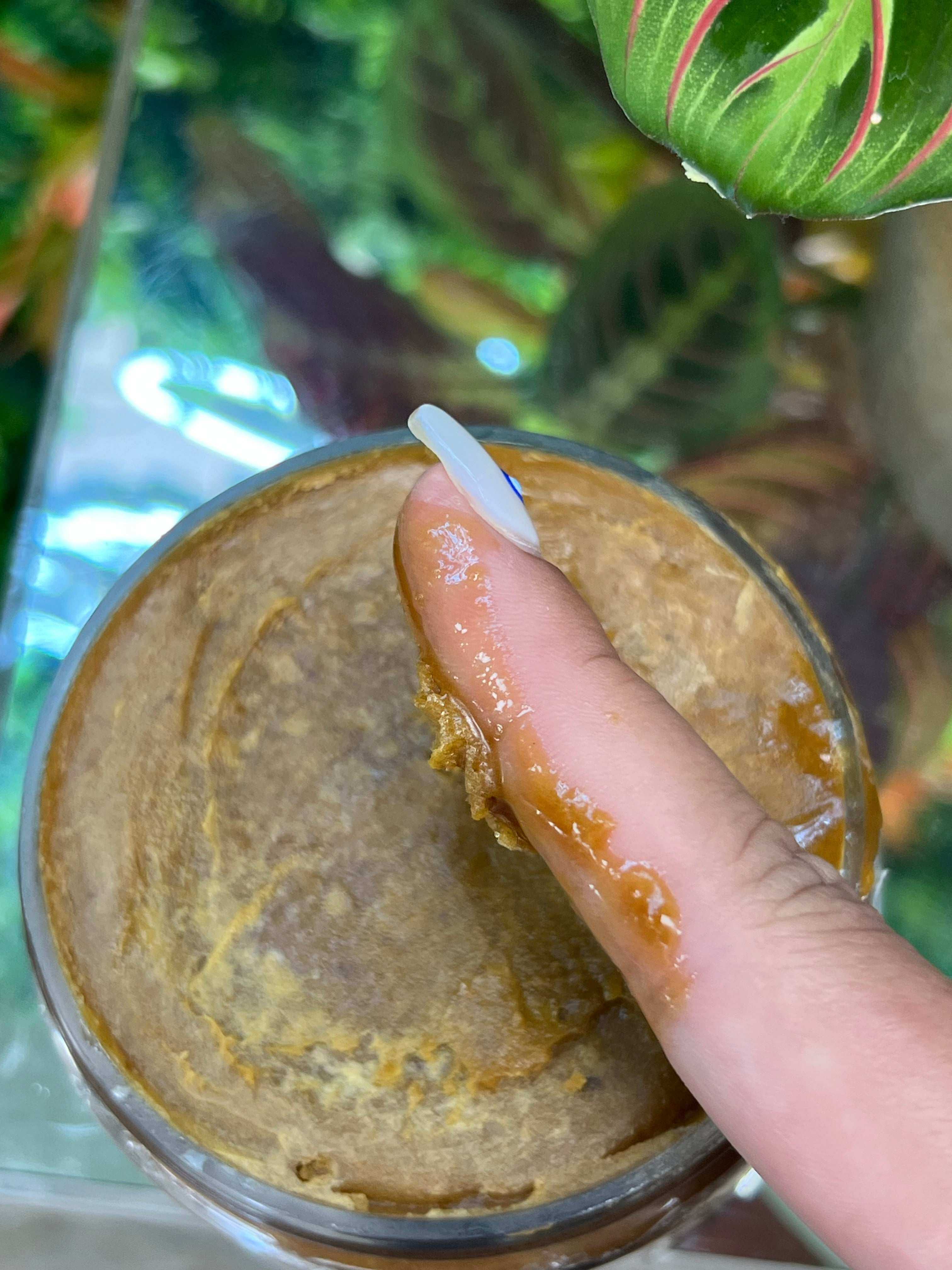 RA COSMETICS 100% Raw Batana Oil for hair (4oz) shown being applied with a finger.