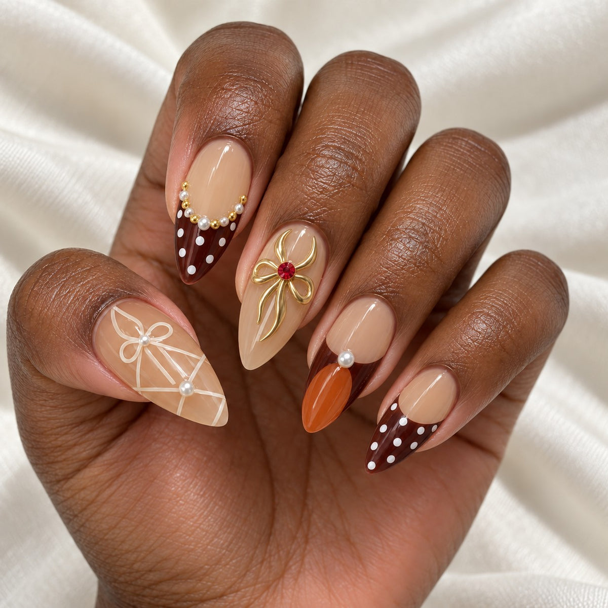 Hand wearing Nude & Burgundy Bow Almond press-on nails